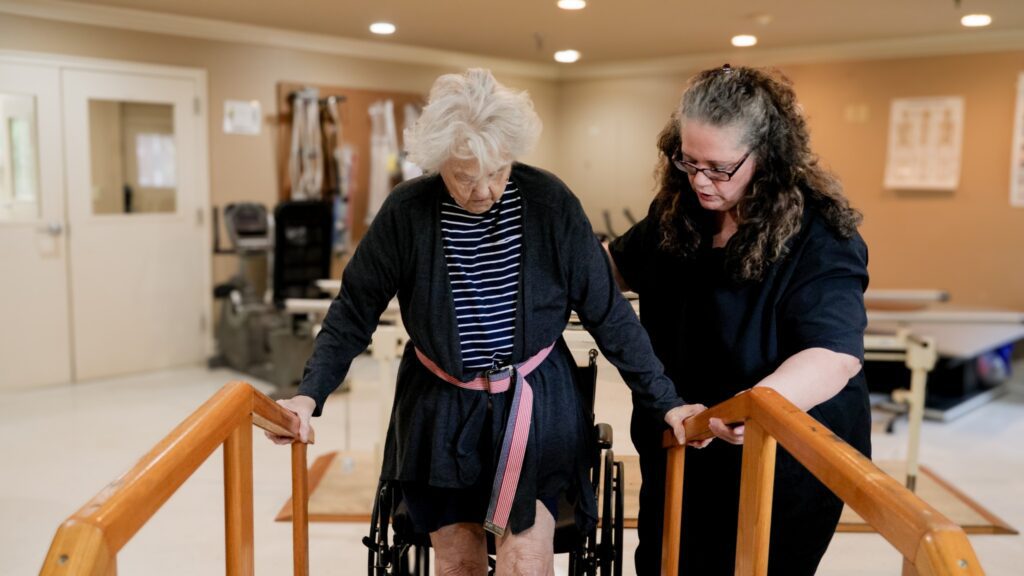 A woman in short term rehab working with a nurse in physical therapy