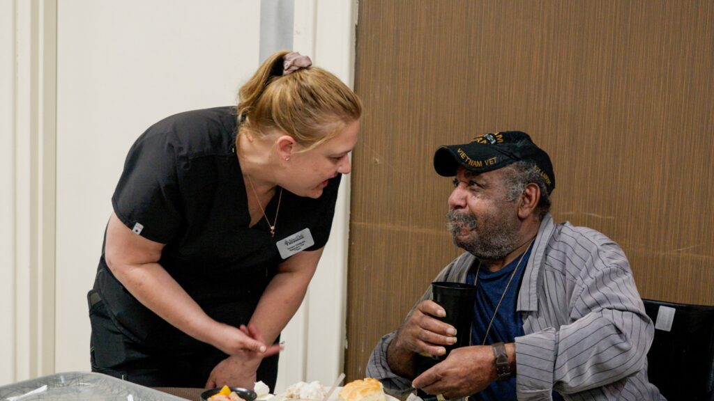 A nurse assists a resident at a skilled nursing nursing home